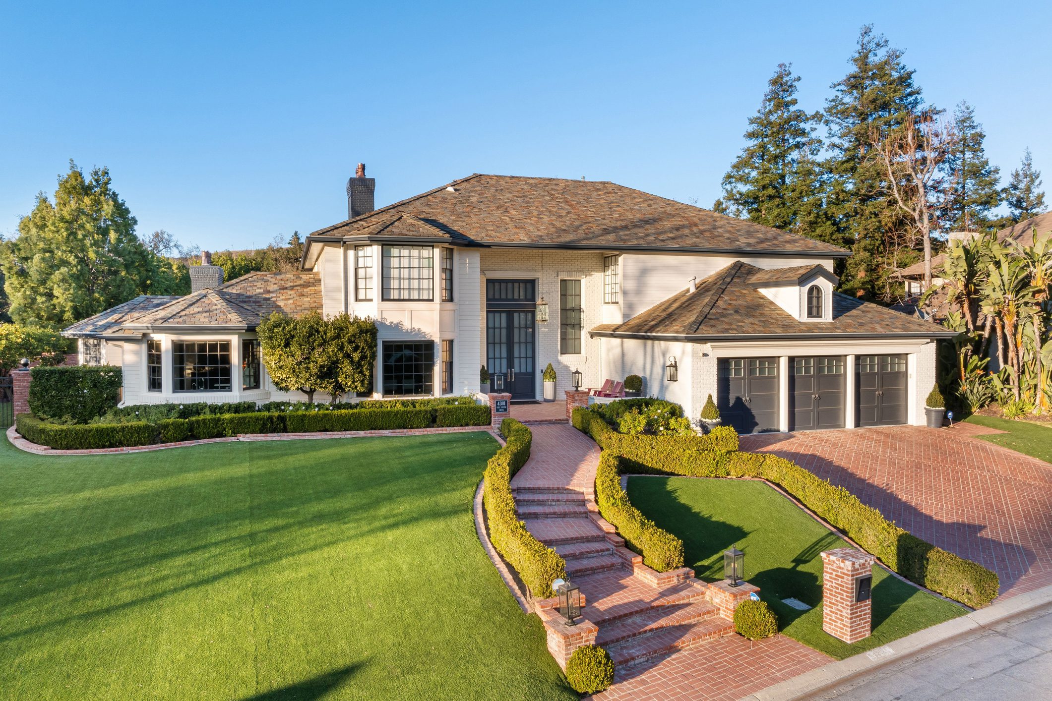 Elegant house with manicured lawn and driveway.
