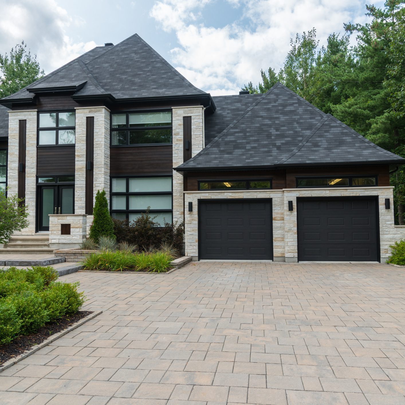 Modern house with driveway and two garages.