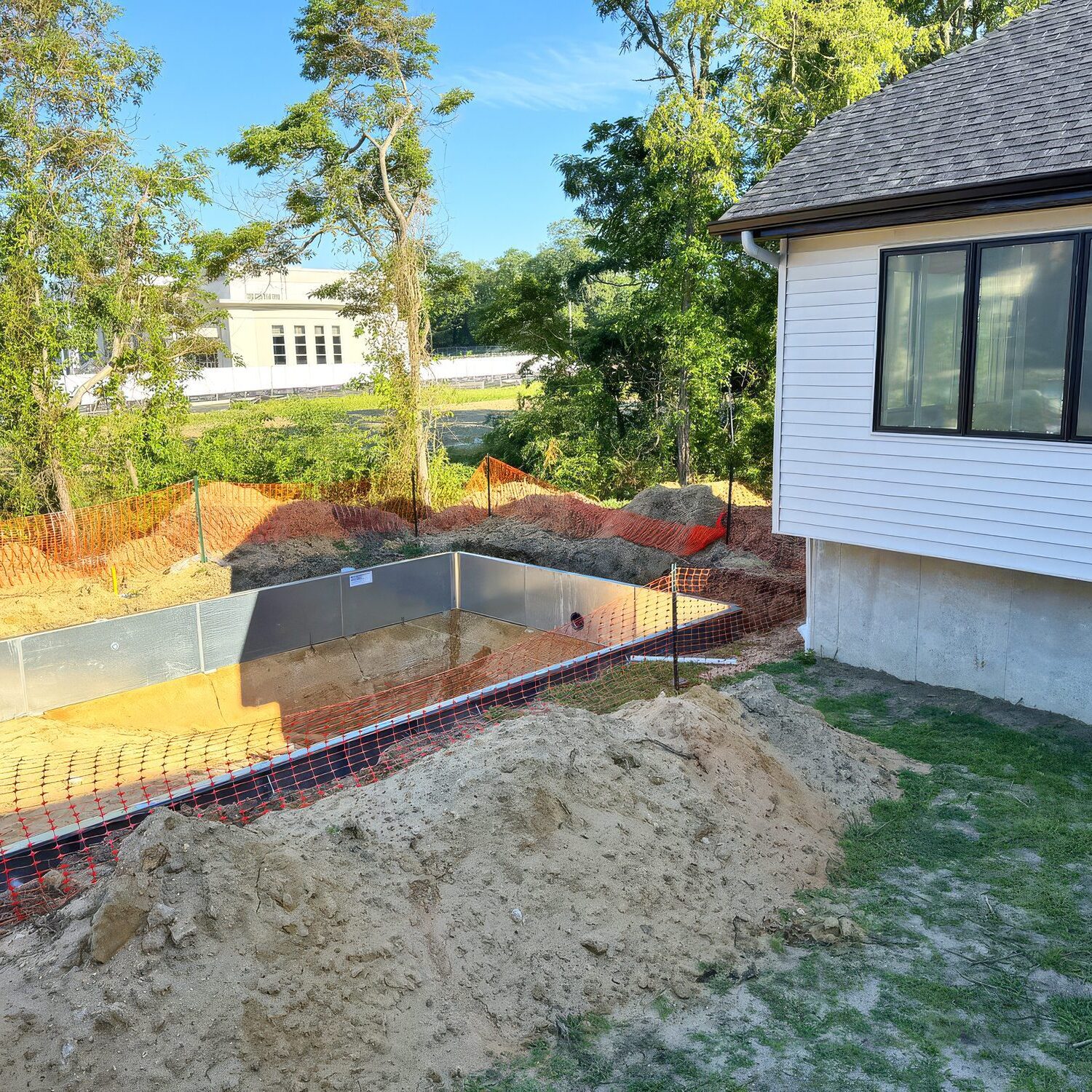 House with backyard pool construction site.